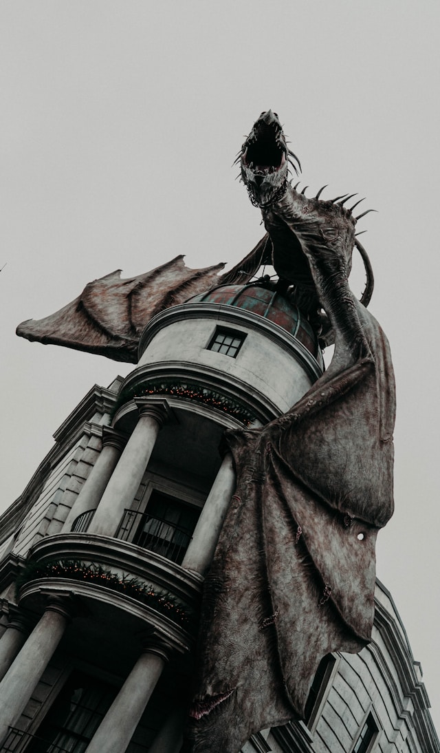 A dragon on top of a building roaring
      towards the camera